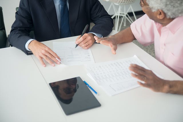 A pair of suited gentlemen sitting at a table, engrossed in a meeting as they examine important documents