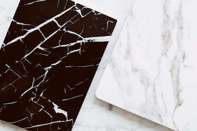 Two black and white marble pieces resting on a white surface