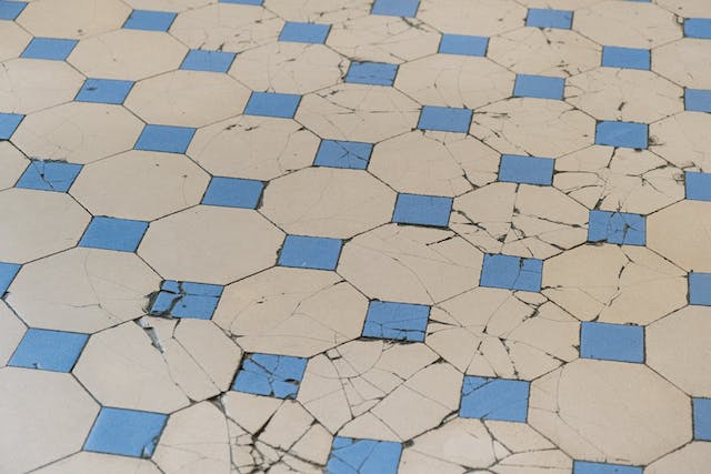 Blue and white tile floor displaying visible cracks