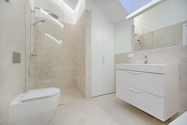 An elegant bathroom featuring a luxurious shower, a sophisticated toilet, and a modern sink