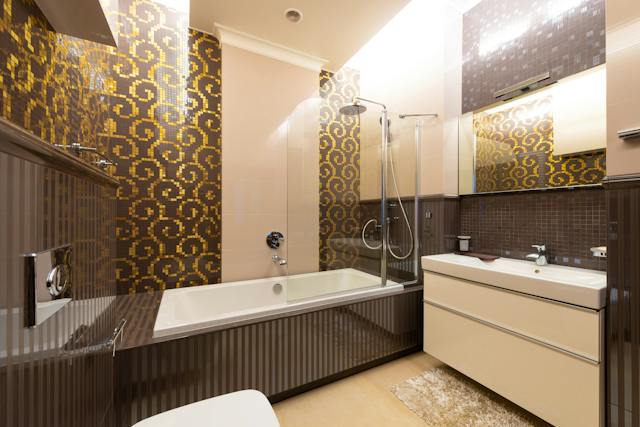 A professionally designed bathroom showcasing a bathtub, toilet, sink, and shower, all surrounded by elegant tiles