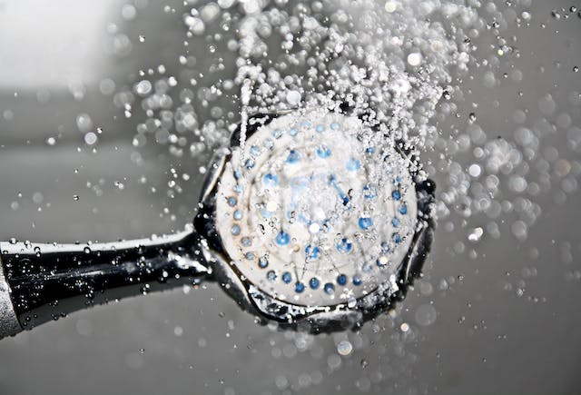 Close-up of a shower head releasing water droplets