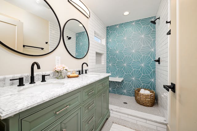 A bathroom that features a stylish combination of blue and white tiles, complemented by a sleek green vanity