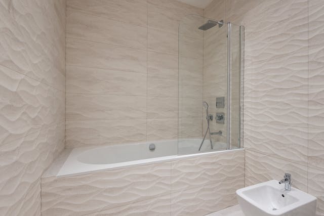 A tiled bathroom featuring a bathtub and toilet