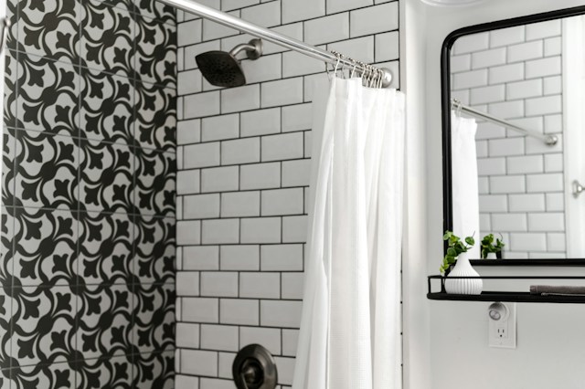 A contemporary bathroom showcasing black and white tiles, complemented by a stylish shower